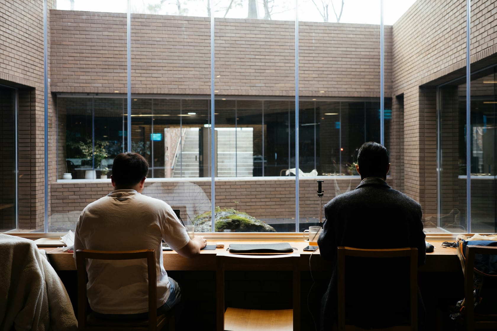Two people working side by side at a shared desk
